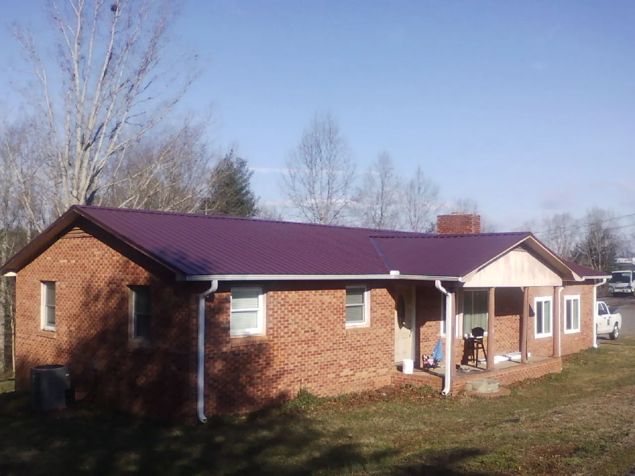 Burgundy metal roof on a brick ranch home with a new addition in Lakeside Marblehead