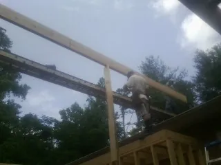Carpenter setting a ridge beam over a new addition frame — Ice Dam Removal by Roofing Brothers in Lakeside Marblehead