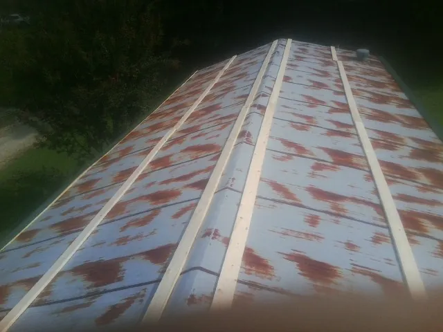 Rusted metal roof panels with new wood purlins before replacement — Storm Damage Roof Repair in Lakeside Marblehead by Roofing Brothers